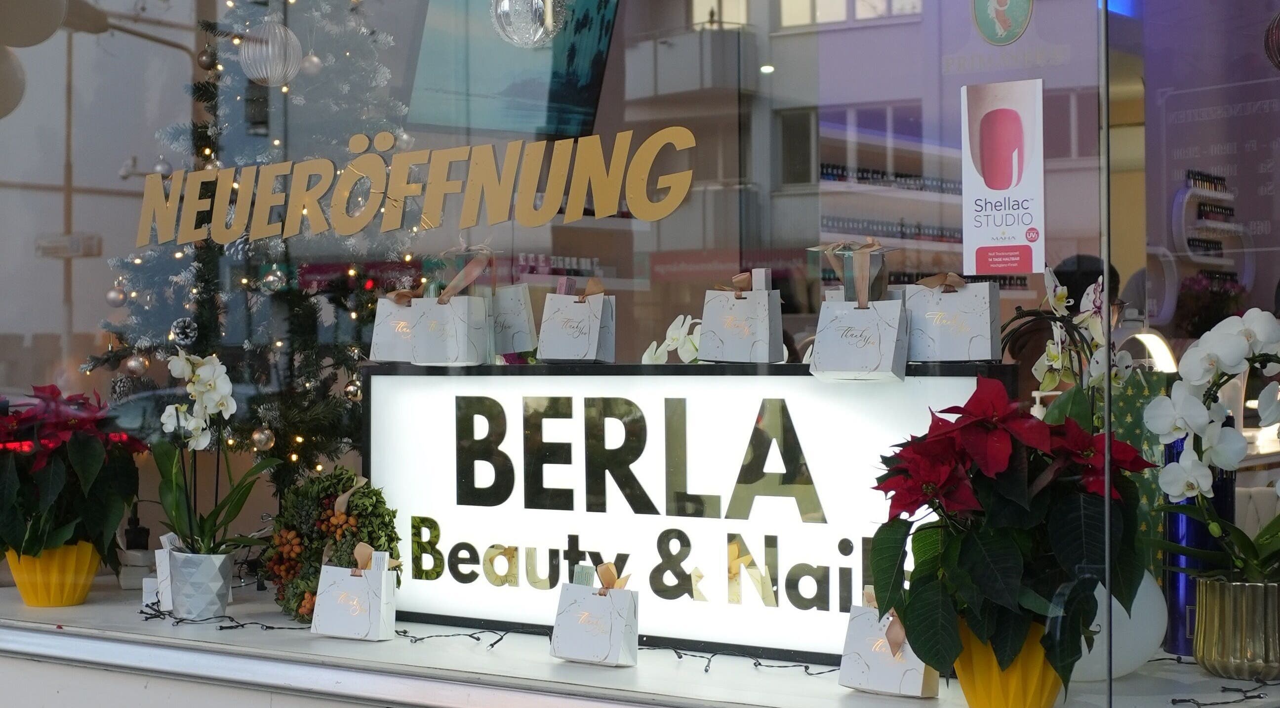 Schaufenster von Berla Nails in Frankfurt Am Main, Hessen, DE dekoriert zur Neueröffnung mit Pflanzen und Geschenken.