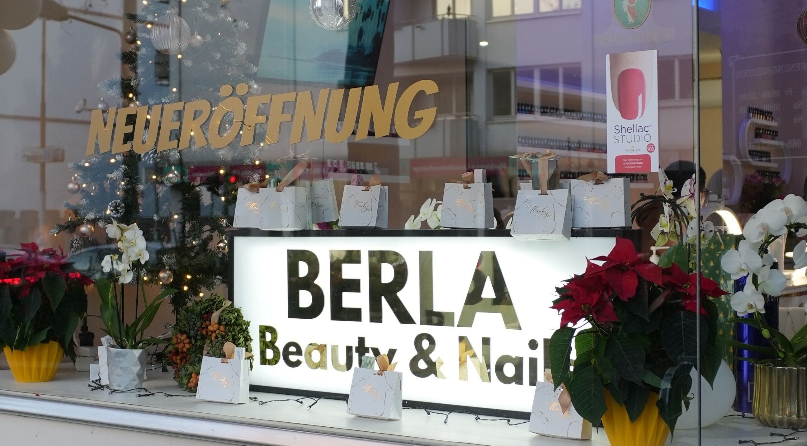 Schaufenster von Berla Nails in Frankfurt Am Main, Hessen, DE dekoriert zur Neueröffnung mit Pflanzen und Geschenken.