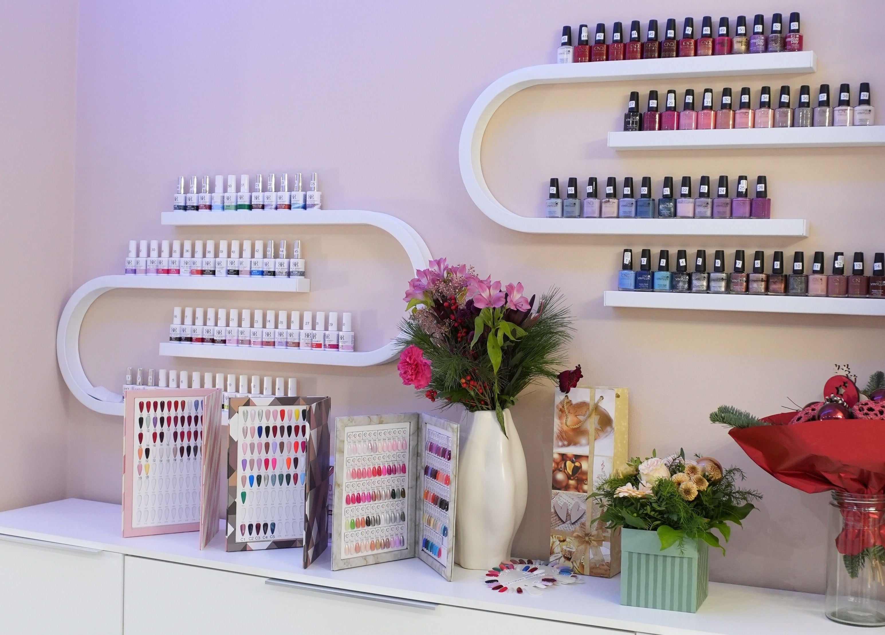 Vitrine mit Nagellacken bei Berla Nails, Frankfurt Am Main, Hessen, DE. Bunte Flaschen und Nageldesigns gezeigt.