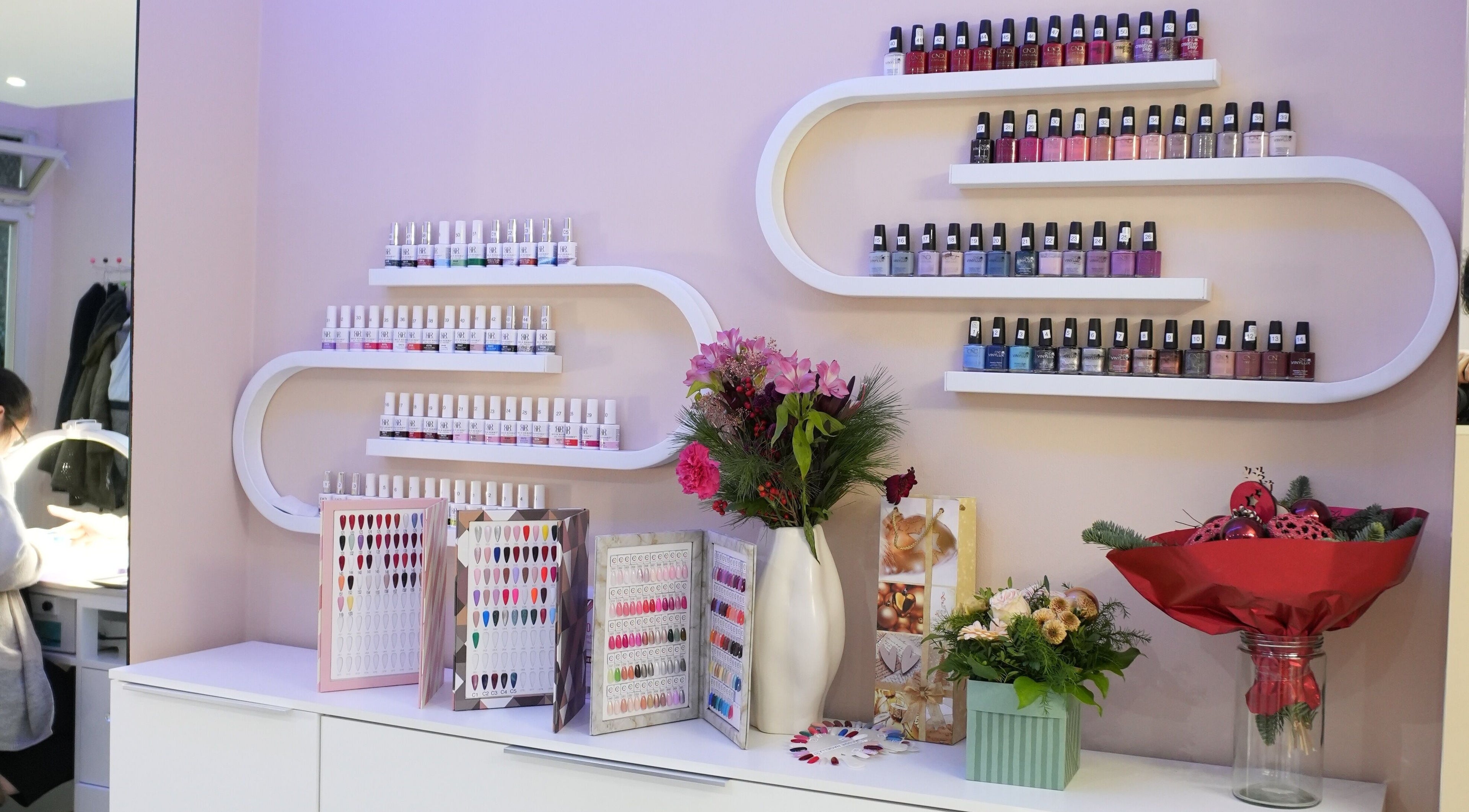 Vitrine mit Nagellacken bei Berla Nails, Frankfurt Am Main, Hessen, DE. Bunte Flaschen und Nageldesigns gezeigt.