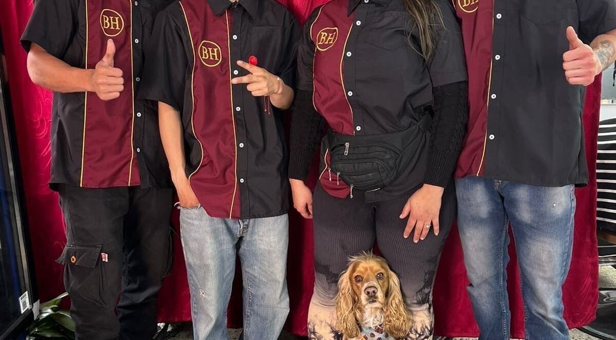 Barber’s House VIP team posing with a dog in Bogotá, D.c., Bogotá, D.c., CO, showcasing unity.