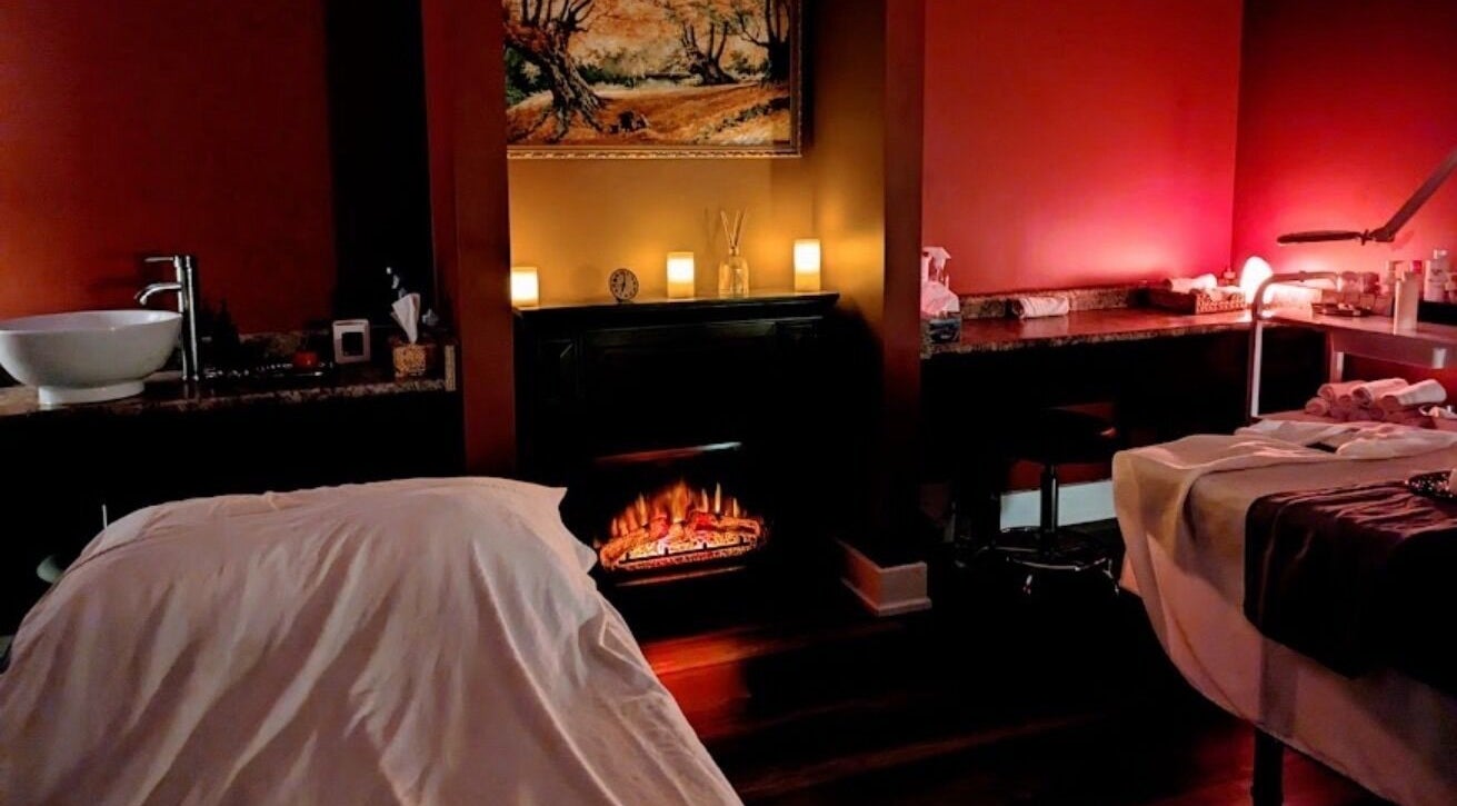 Relaxing massage room at Exhale Spa and WellnessElite, Toronto, Ontario, CA with ambient lighting and fireplace.