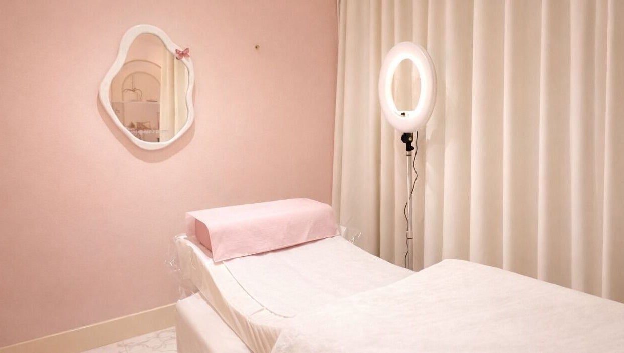 Peaceful treatment room at Dinivé Beauty in London, England, GB, with soft pink decor and a treatment bed.
