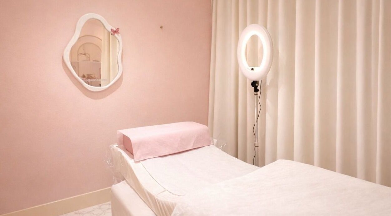 Peaceful treatment room at Dinivé Beauty in London, England, GB, with soft pink decor and a treatment bed.