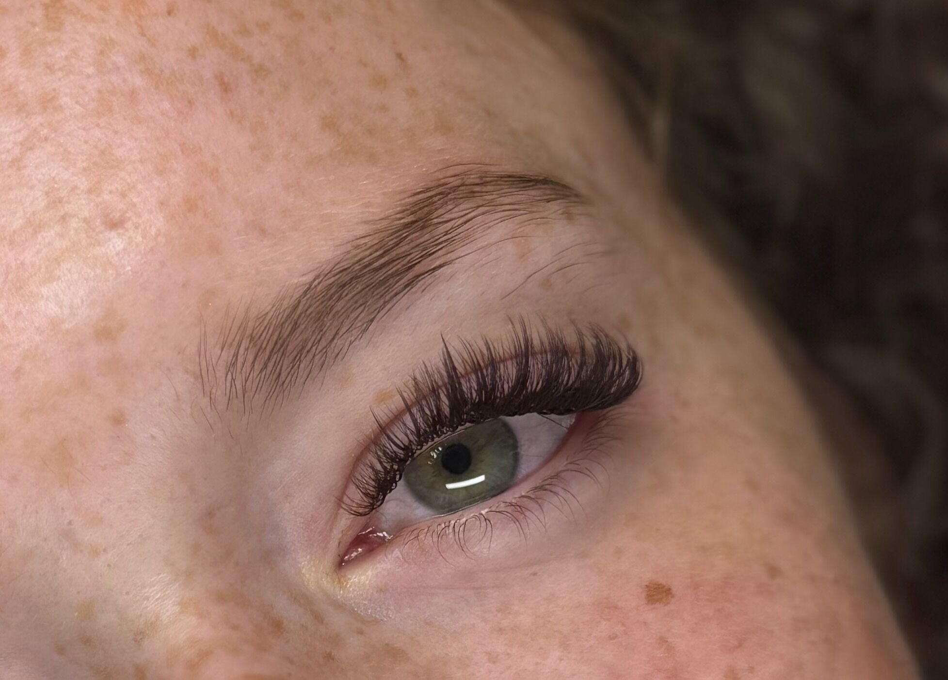 Close-up of eye with lush lashes at Dinivé Beauty, London, England, GB, showcasing expert eyelash styling.