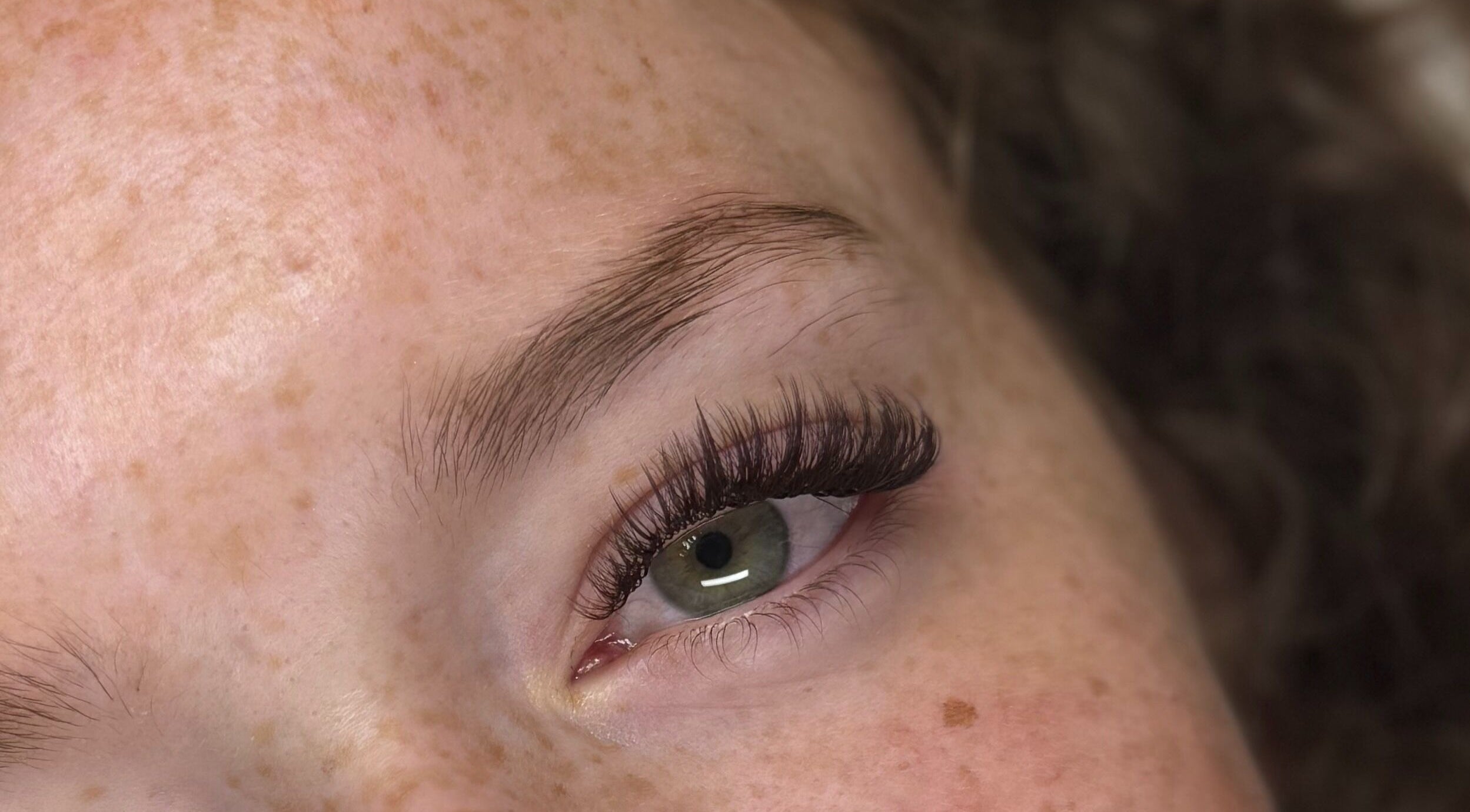 Close-up of eye with lush lashes at Dinivé Beauty, London, England, GB, showcasing expert eyelash styling.