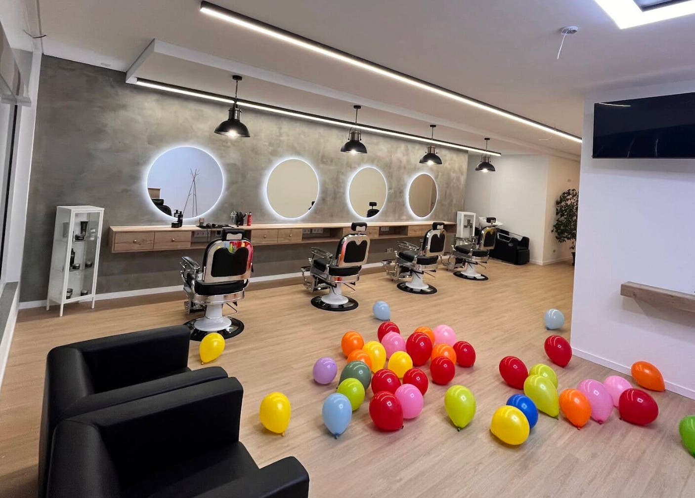 Modern interior of Barbearia Lusitania with colorful balloons in Santo António Dos Cavaleiros, Lisboa, PT.