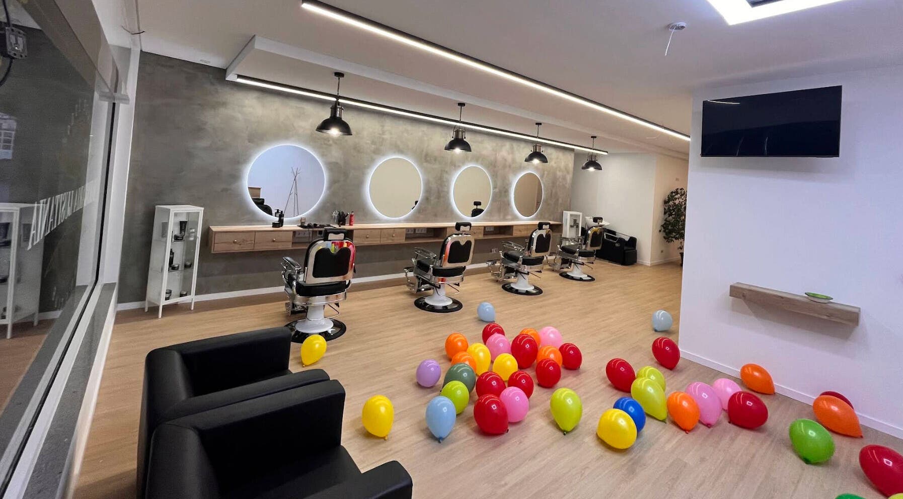 Modern interior of Barbearia Lusitania with colorful balloons in Santo António Dos Cavaleiros, Lisboa, PT.