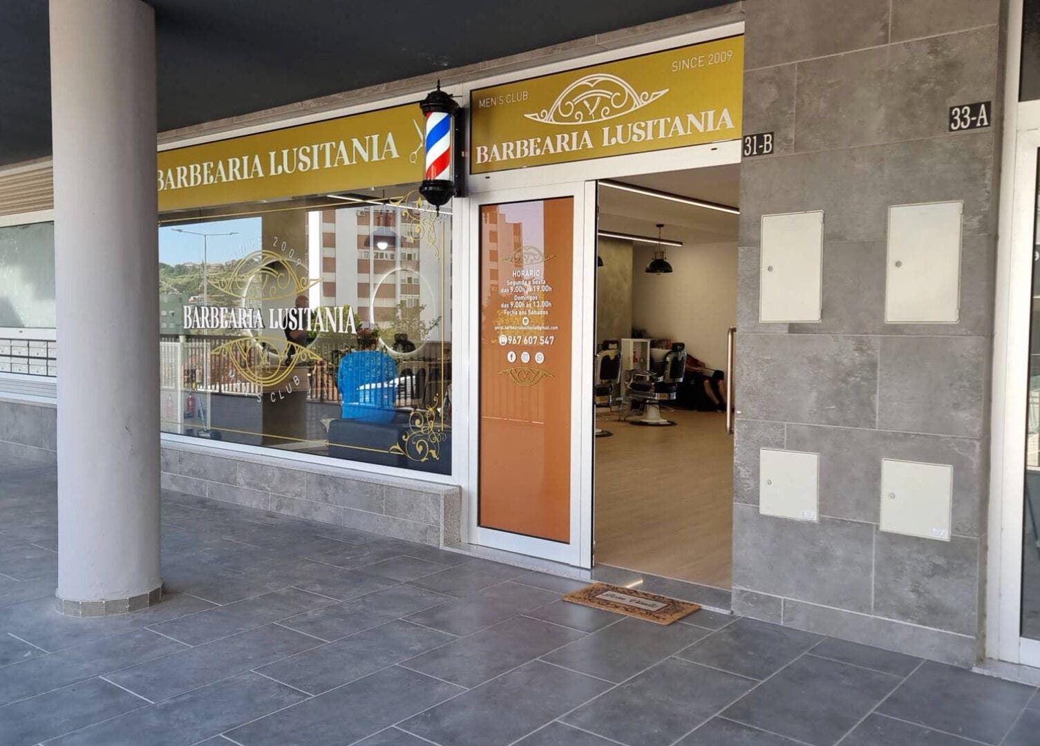 Entrance of Barbearia Lusitania in Santo António Dos Cavaleiros, Lisboa, PT, showcasing modern design.