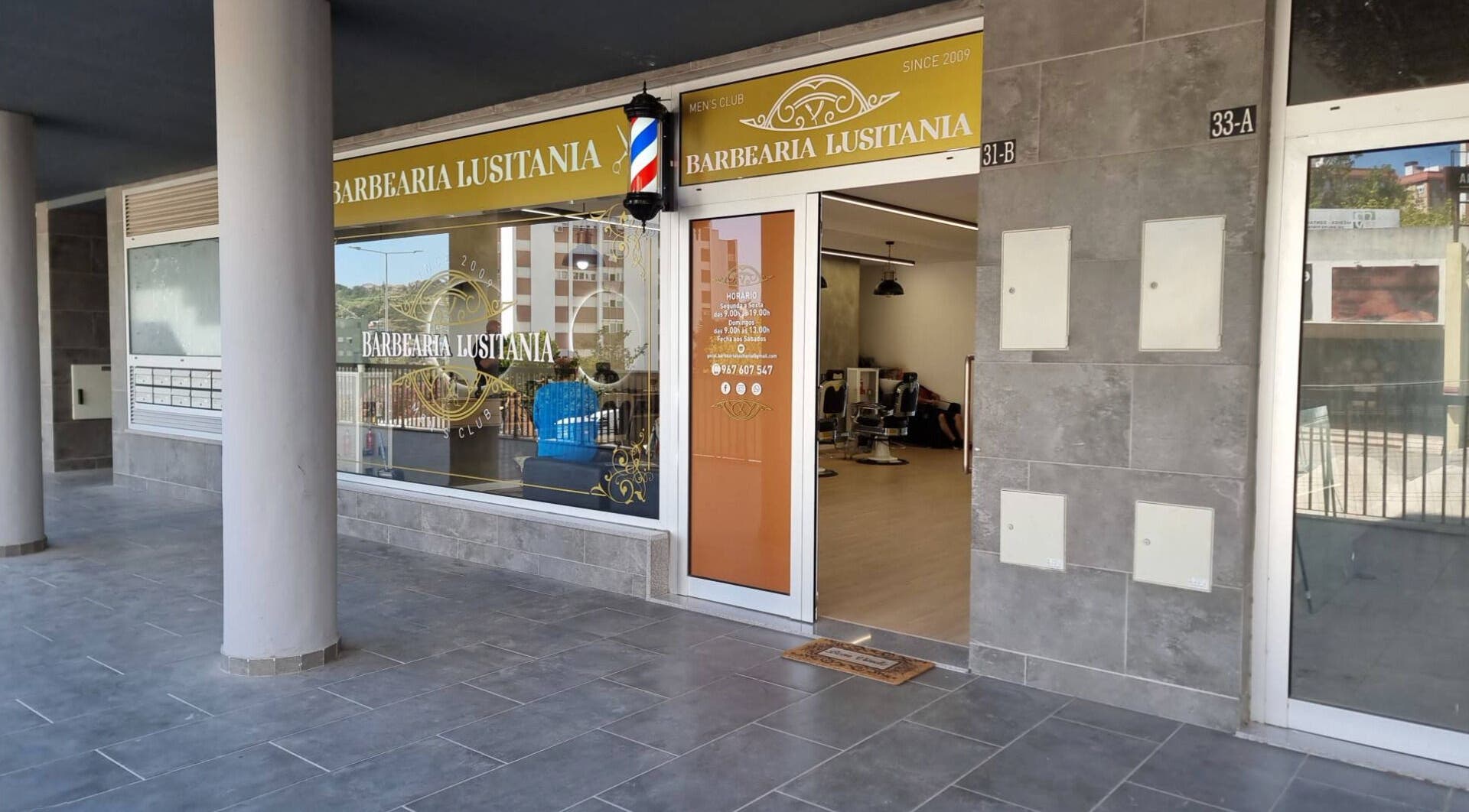 Entrance of Barbearia Lusitania in Santo António Dos Cavaleiros, Lisboa, PT, showcasing modern design.