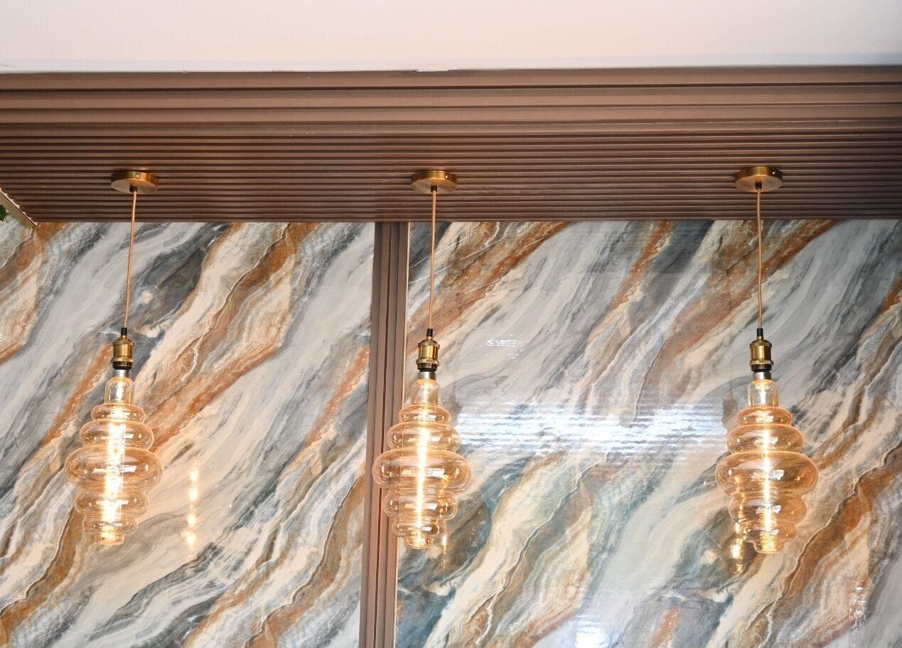 Chic pendant lights against marble wall at Leila’s Beauty Bar, Pretoria, Gauteng, ZA.