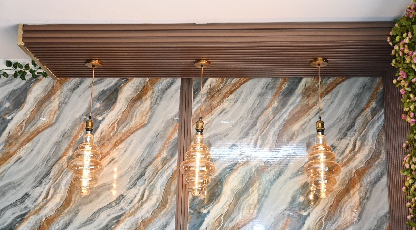 Chic pendant lights against marble wall at Leila’s Beauty Bar, Pretoria, Gauteng, ZA.