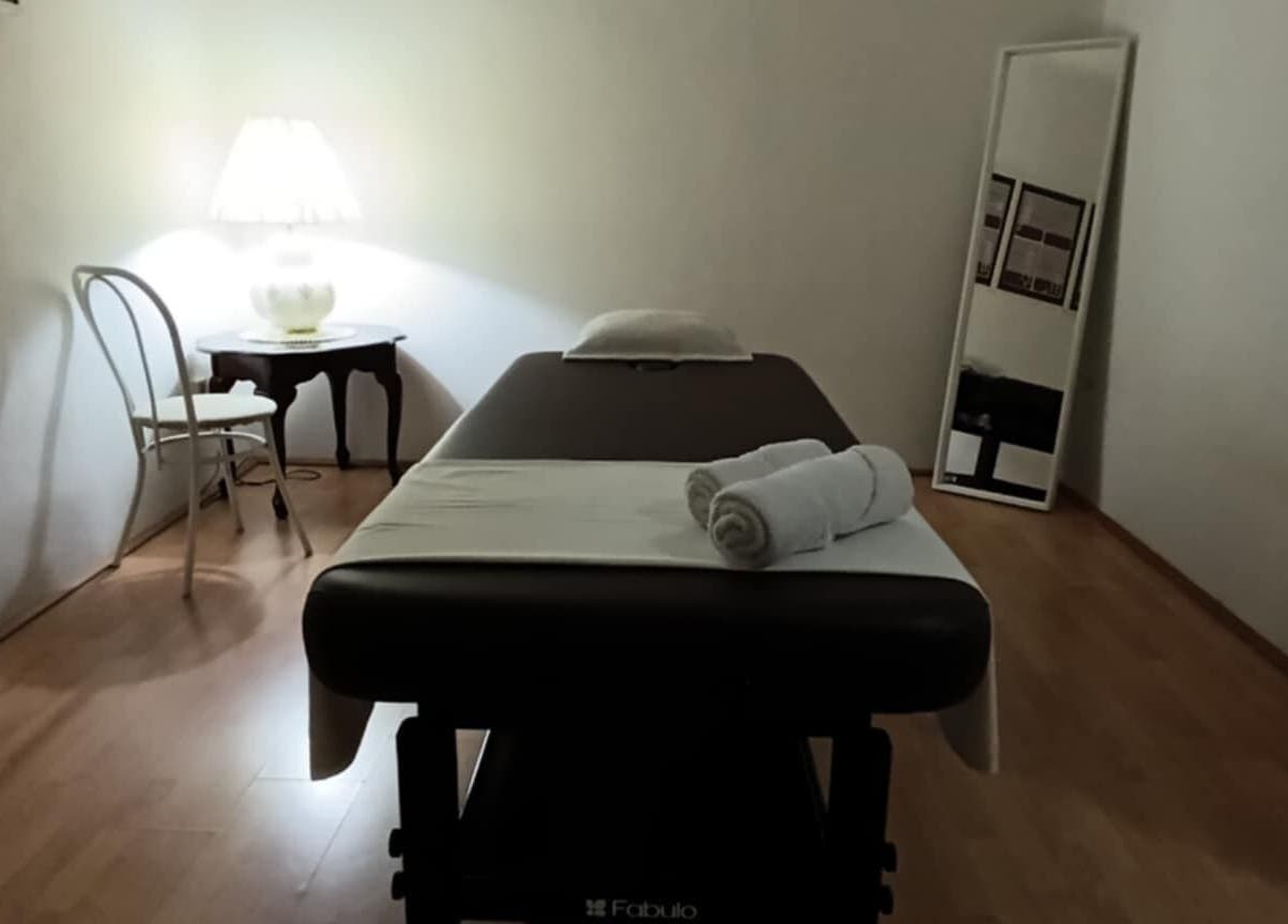 Tranquil massage room at ONE Thai Solution Massage, Budapest, Magyar, HU. Cozy ambiance with table and warm lighting.