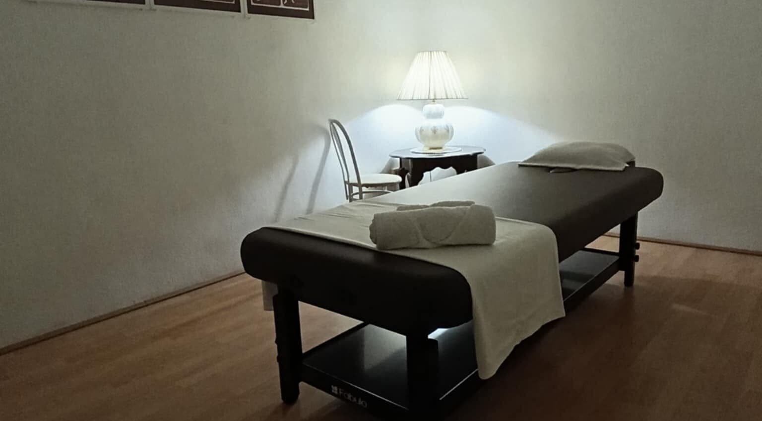 Tranquil massage room at ONE Thai Solution Massage, Budapest, Magyar, HU with cozy lighting and comfortable table.
