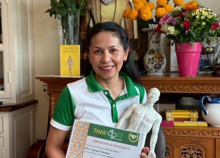 Owner at ONE Thai Solution Massage in Budapest, Magyar, HU holding a certificate of excellence next to vibrant flowers.