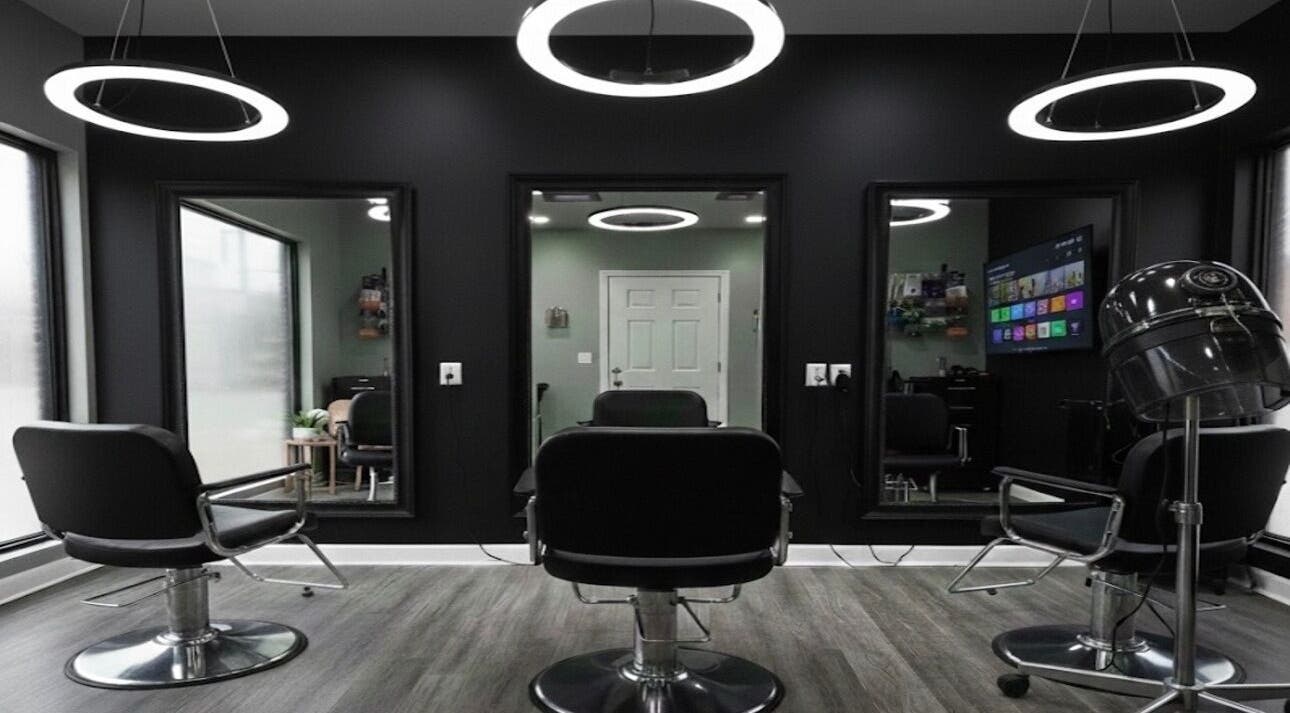 Modern salon interior at Black Laced by Carter in Charlotte, North Carolina, US with sleek black chairs and mirrors.