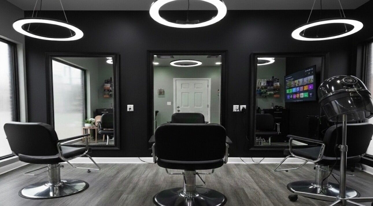 Modern salon interior at Black Laced by Carter in Charlotte, North Carolina, US with sleek black chairs and mirrors.