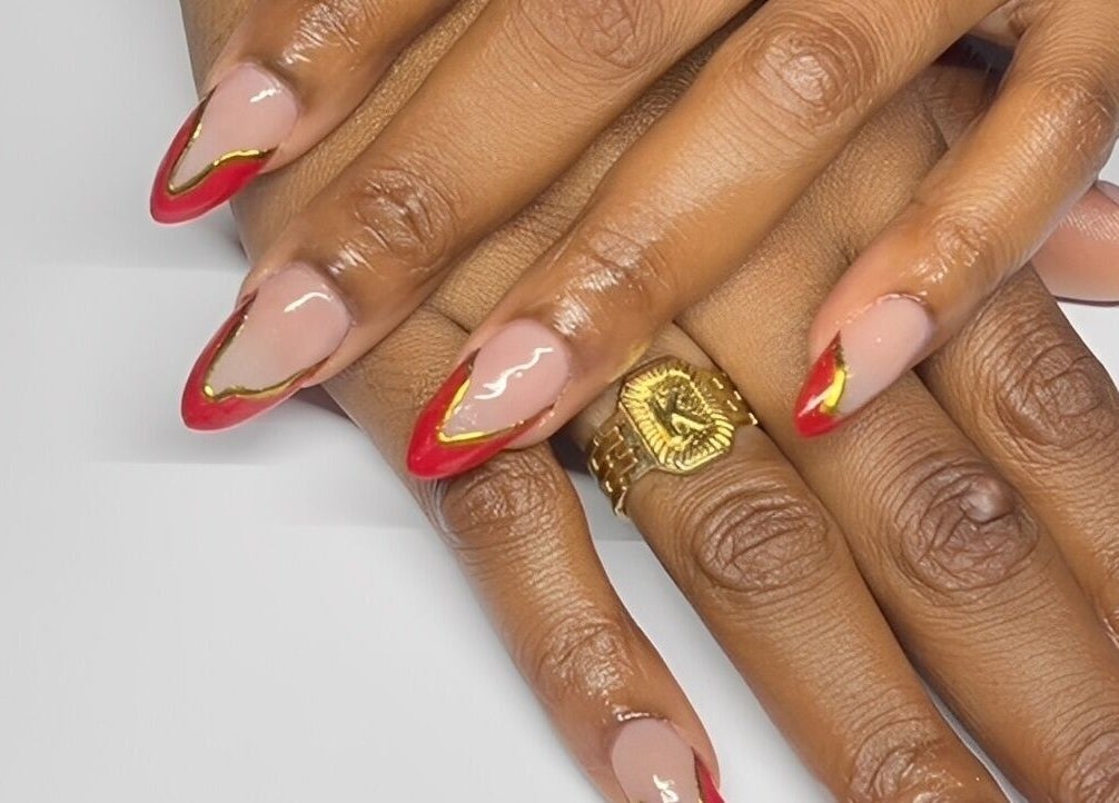 Stylish red and gold manicure at True Beauty, Charlotte, Charlotte, VC. Perfect blend of elegance and fashion.