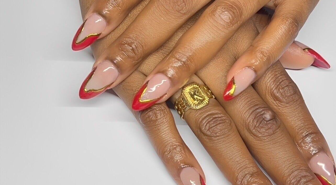 Stylish red and gold manicure at True Beauty, Charlotte, Charlotte, VC. Perfect blend of elegance and fashion.