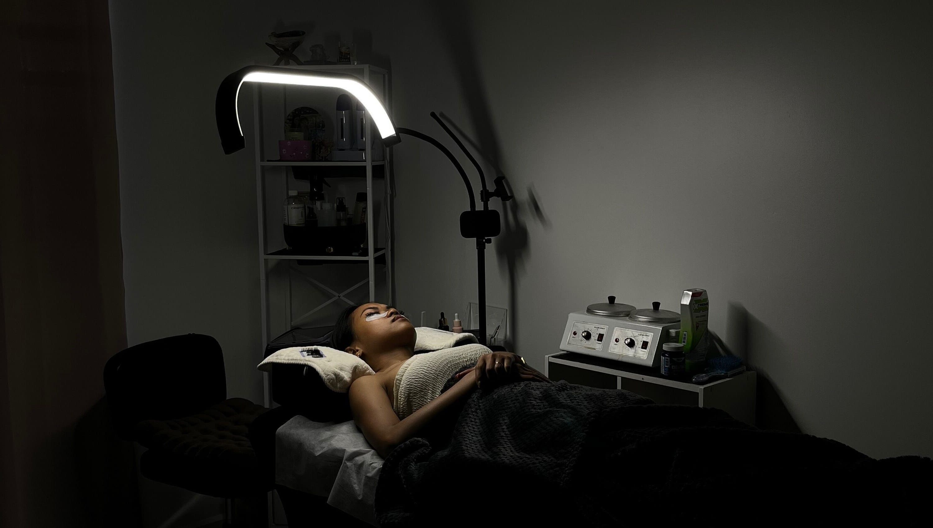 Serene treatment room at POISE BEAUTY, Paramaribo, SR, showcasing a client enjoying a spa session under soft lighting.