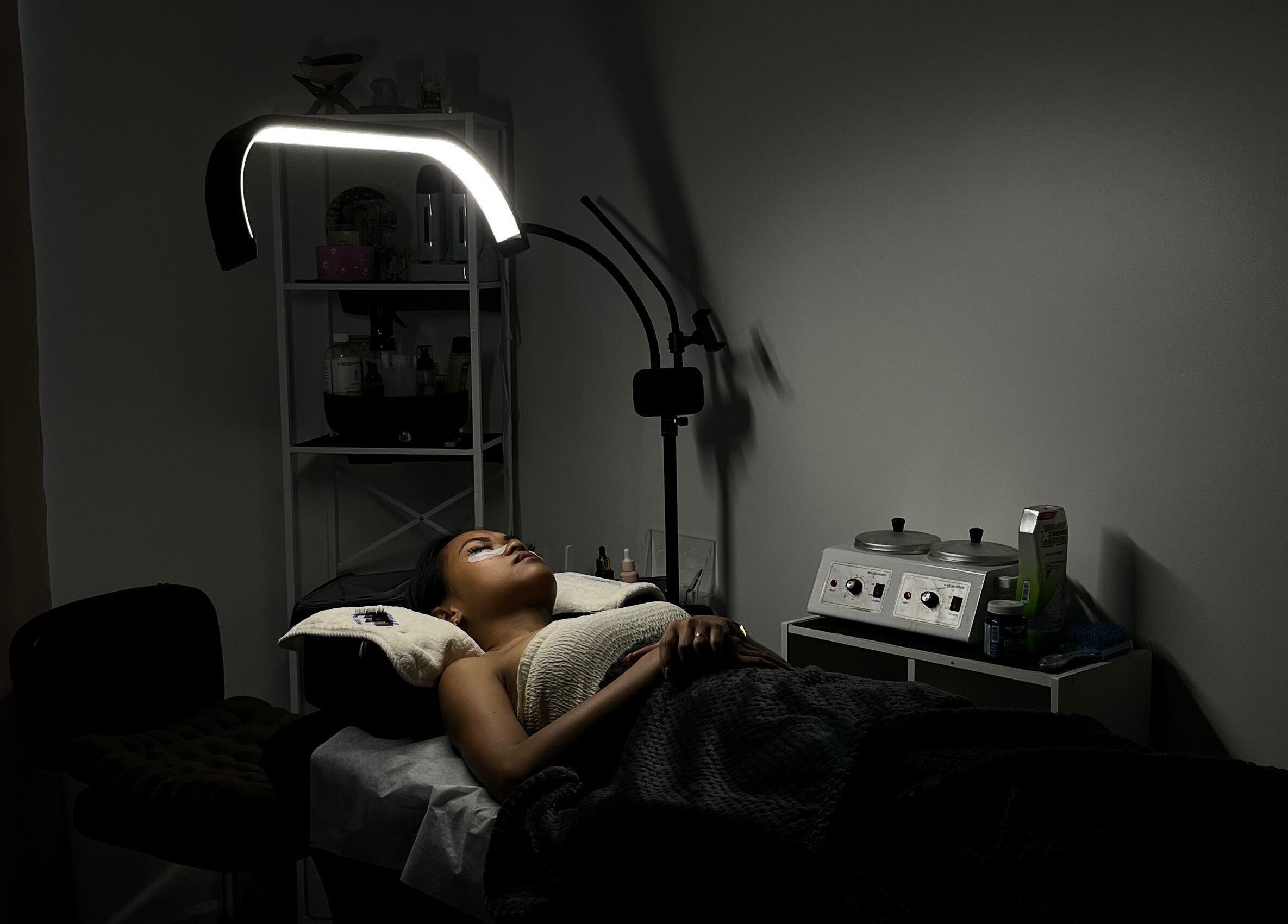 Serene treatment room at POISE BEAUTY, Paramaribo, SR, showcasing a client enjoying a spa session under soft lighting.