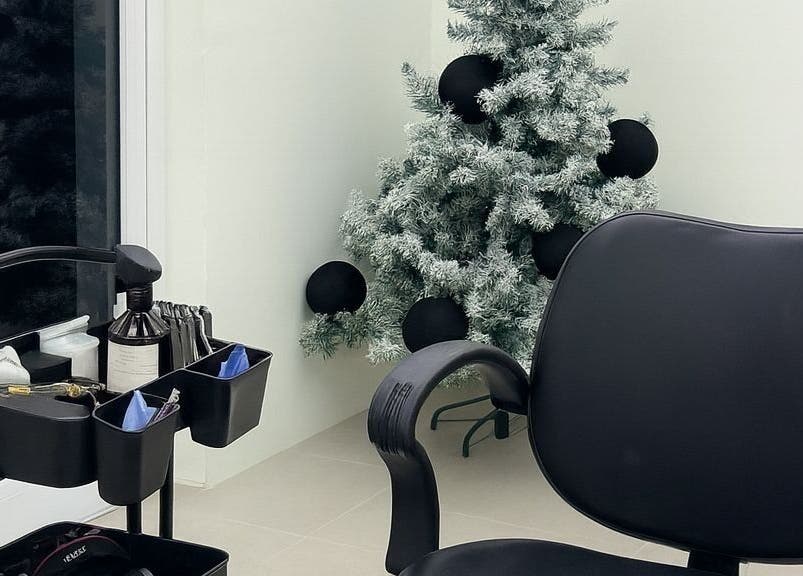 Cozy setup at Barber N’ The Hood, Kralendijk, Bonaire with salon chair and decorated tree.
