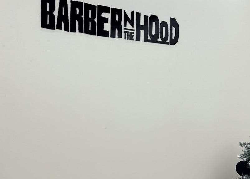 Barber N’ The Hood sign on wall with a small plant, Kralendijk, Bonaire, BQ.