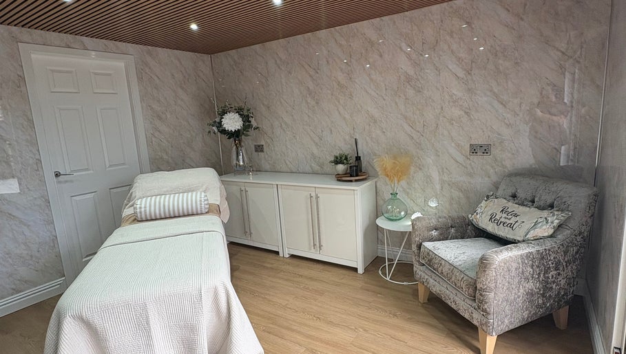 Calm treatment room at The Retreat in Barnsley, England, GB, featuring a cozy chair and massage table.