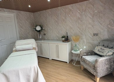 Calm treatment room at The Retreat in Barnsley, England, GB, featuring a cozy chair and massage table.