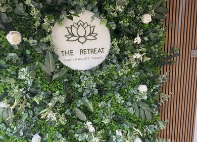 Greenery wall with 'The Retreat' logo at Barnsley, England, GB showcasing beauty and holistic therapy.
