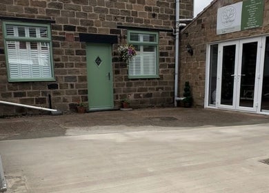 The Retreat entrance in Barnsley, England, GB with green door, stone walls, and plant decor.