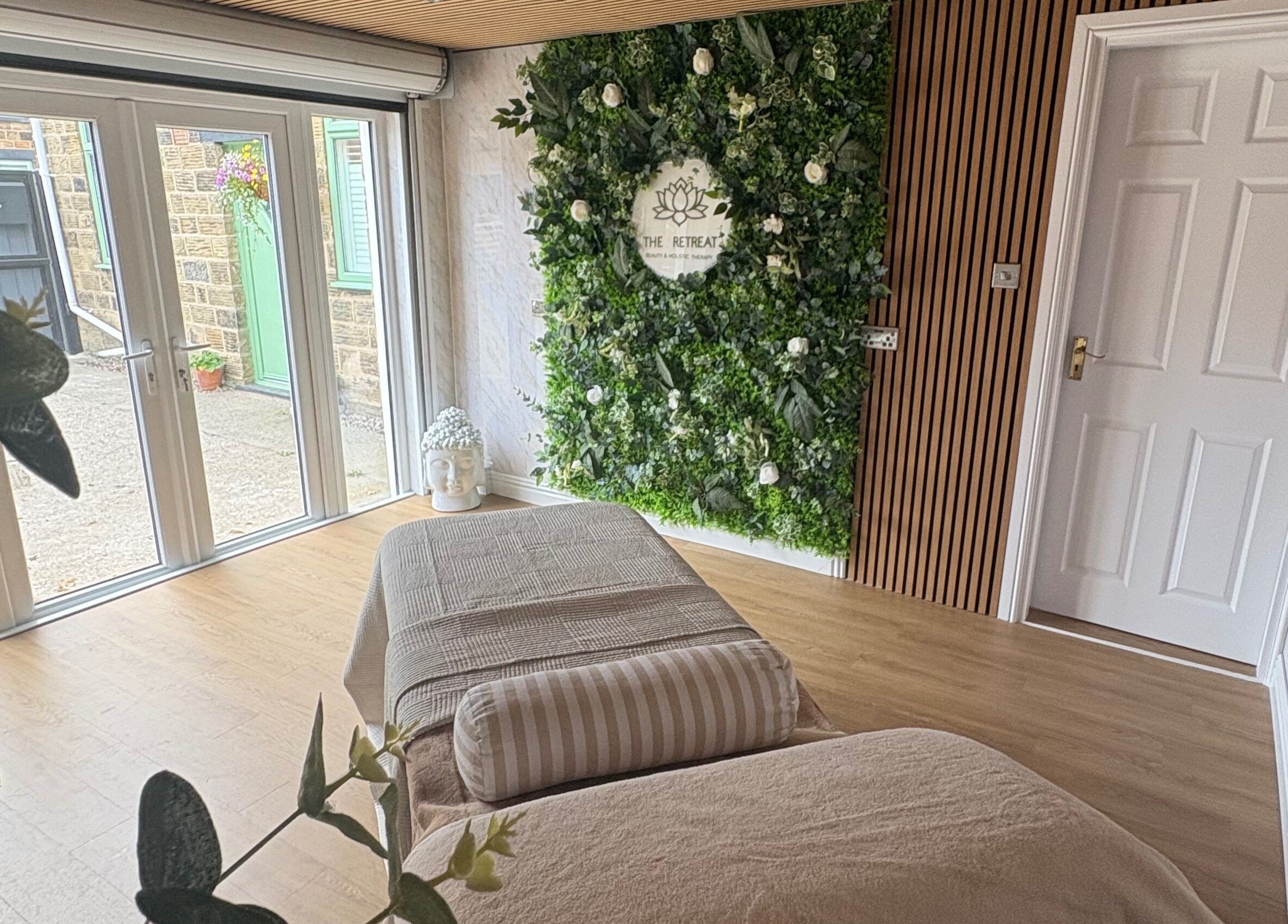 Relaxing treatment room at The Retreat, Barnsley, England, GB with a lush green plant wall.
