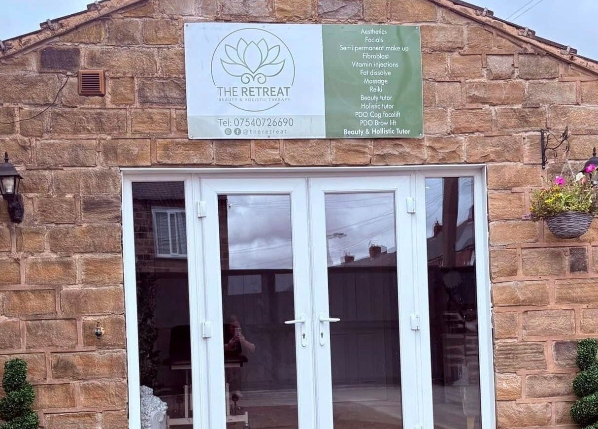 Chic entrance of The Retreat, Barnsley, England, GB showcasing elegant glass doors and stone wall.