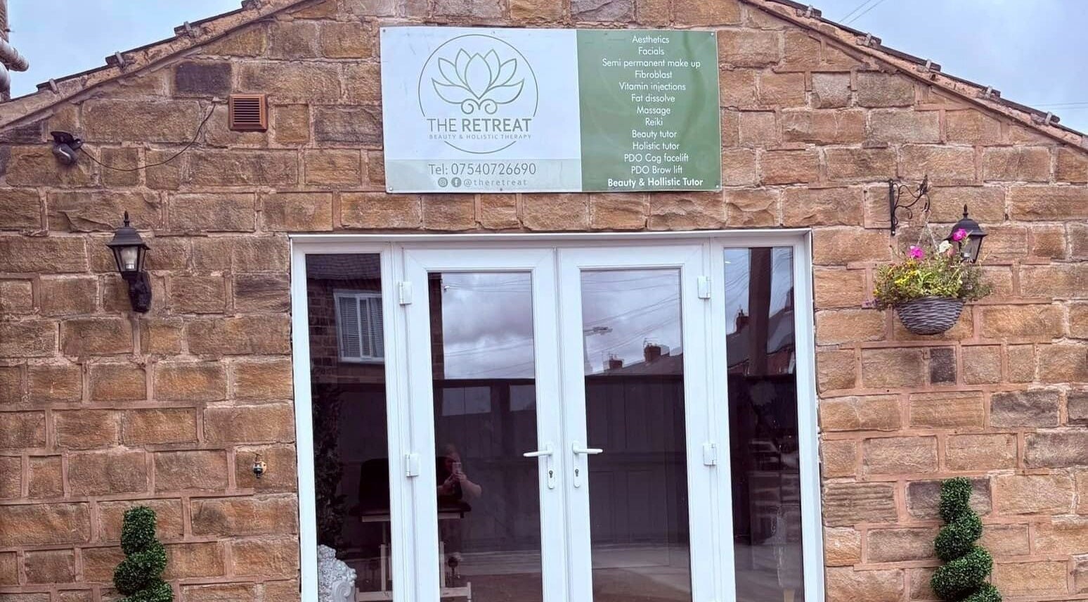 Chic entrance of The Retreat, Barnsley, England, GB showcasing elegant glass doors and stone wall.