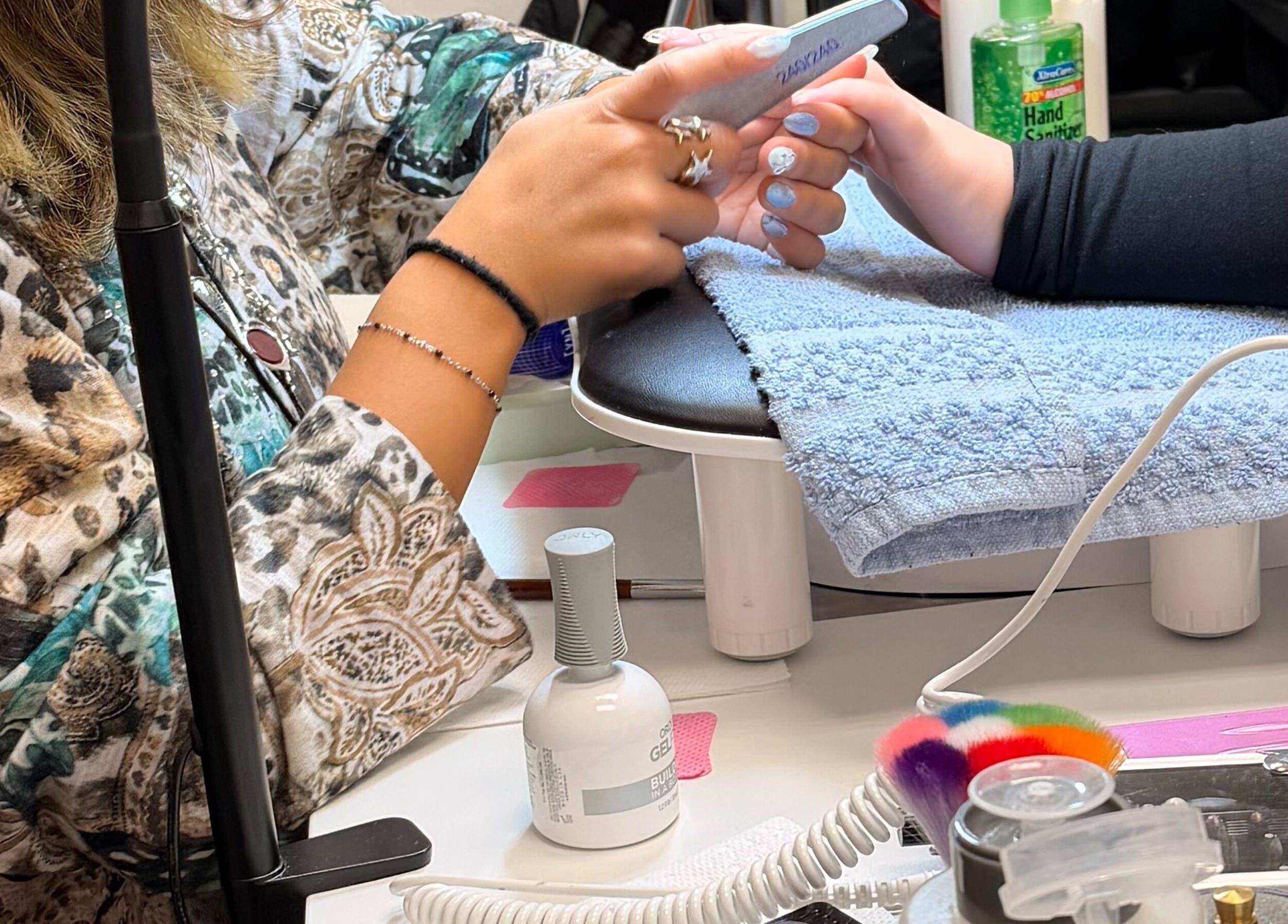 Manicure in progress at Gloss N Bare Studio, Midvale, Utah. Hands being beautifully shaped and polished.