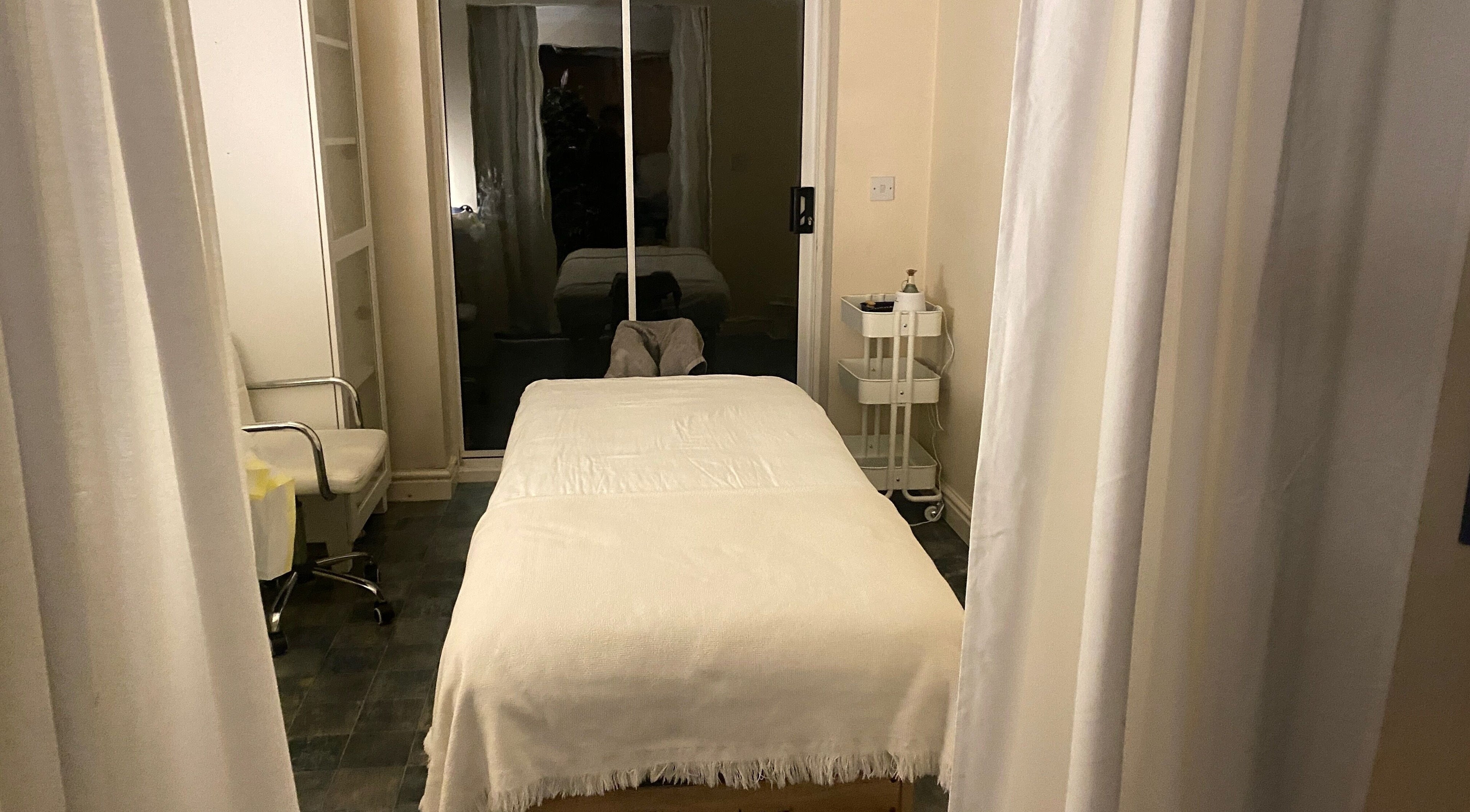 Tranquil massage room at Faye Massage & Wellness, Liverpool, England, GB, featuring a cozy treatment table.