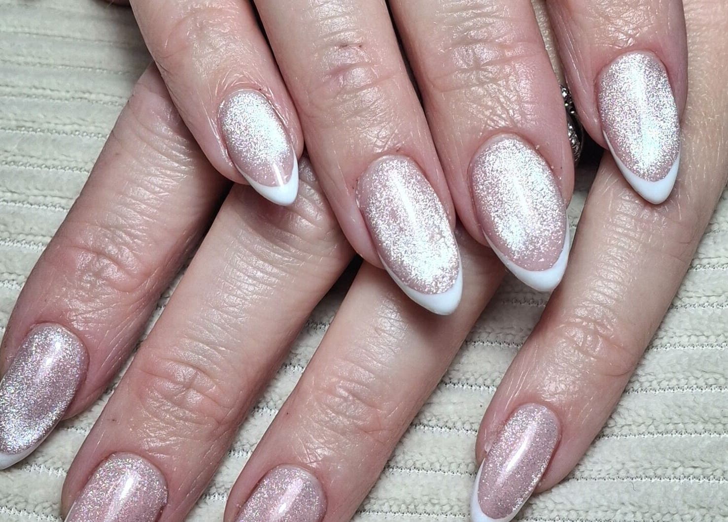 Elegant glittery French manicure at The Toni Touch, Bolton, England, GB. Perfect nail art for a glamorous look.