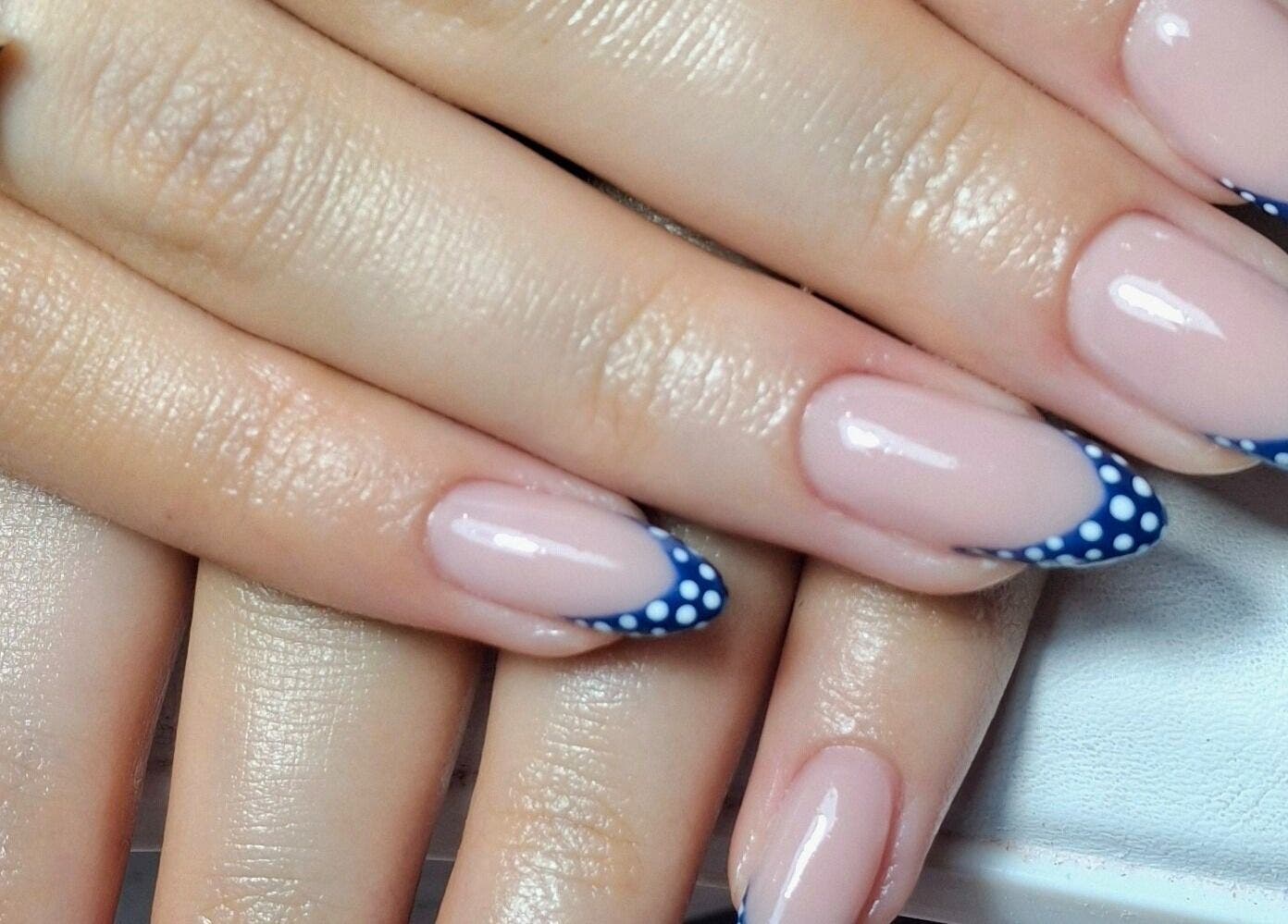 Stylish polka dot navy tips manicure at The Toni Touch, Bolton, England, GB, showcasing elegant nail art.