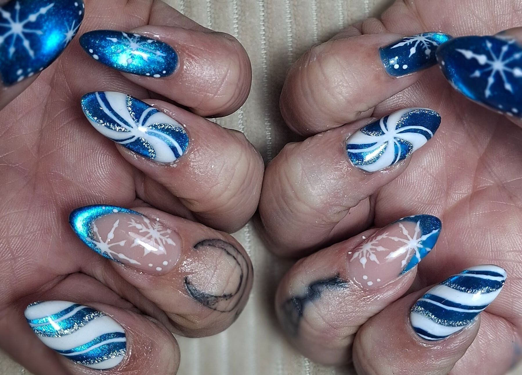 Blue and white snowflake nail art at The Toni Touch, Bolton, England, GB.