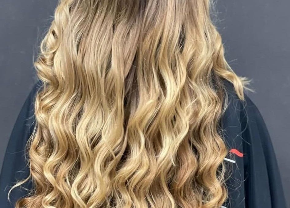 Capelli ondulati biondi di Shanè Parrucchieri a Campania, Campania, IT, che mostrano uno stile elegante.