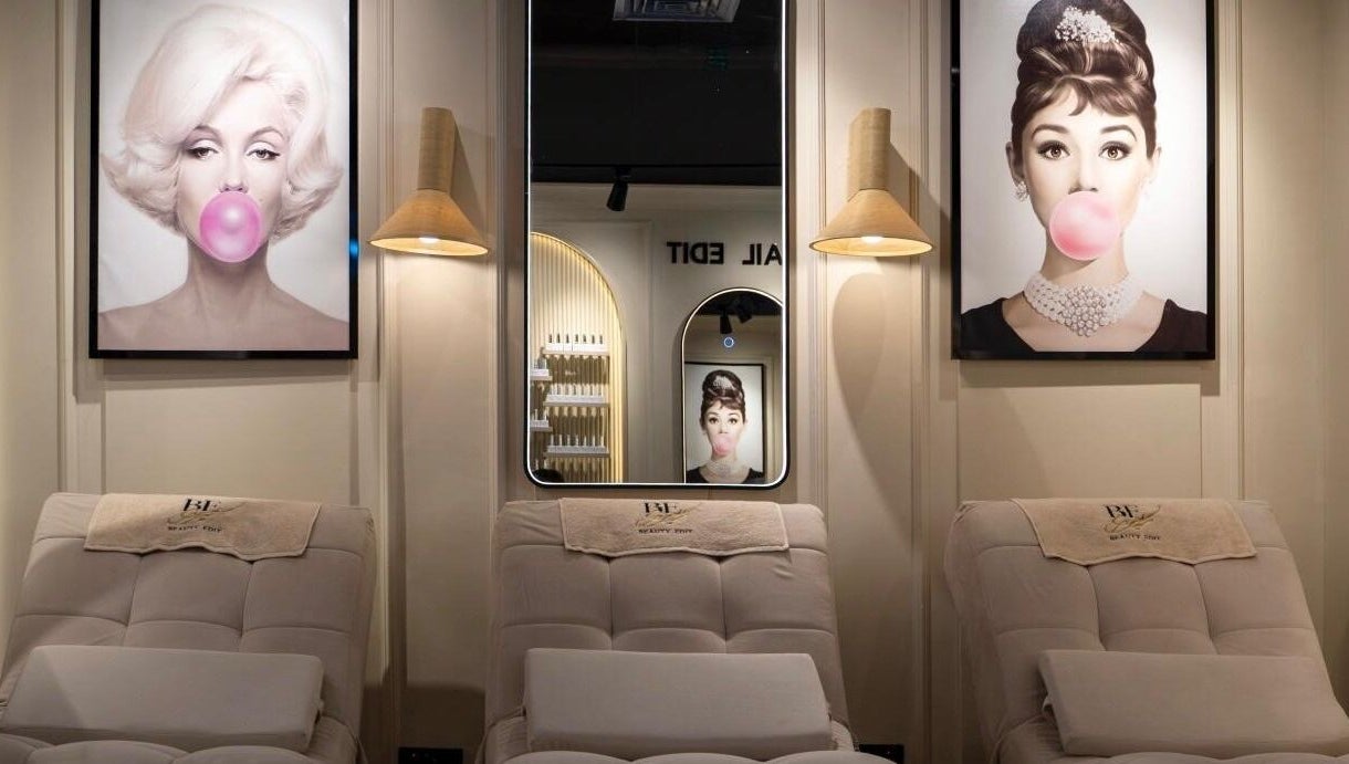 Stylish interior of Beauty Edit Dubai in Dubai, AE featuring iconic portraits and plush seating.