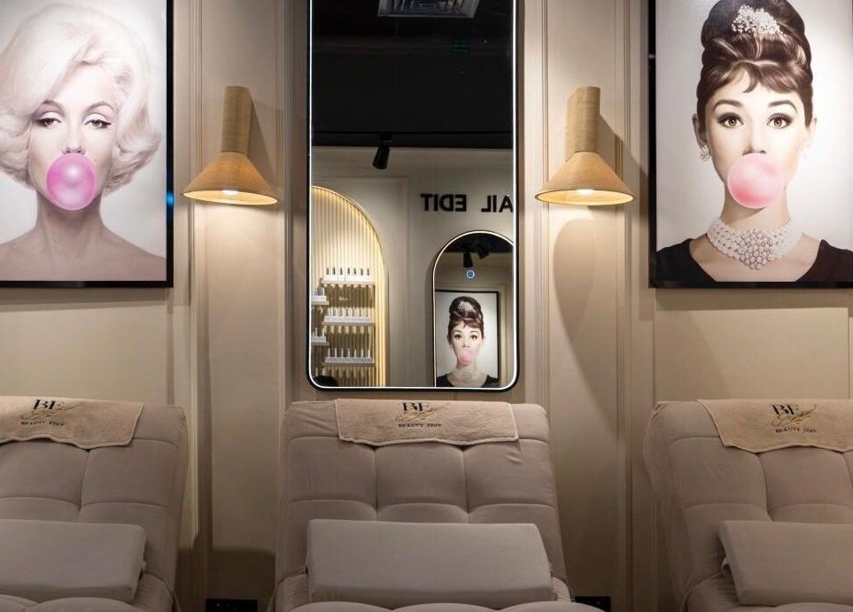 Stylish interior of Beauty Edit Dubai in Dubai, AE featuring iconic portraits and plush seating.
