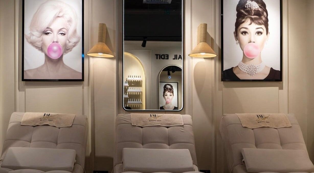 Stylish interior of Beauty Edit Dubai in Dubai, AE featuring iconic portraits and plush seating.