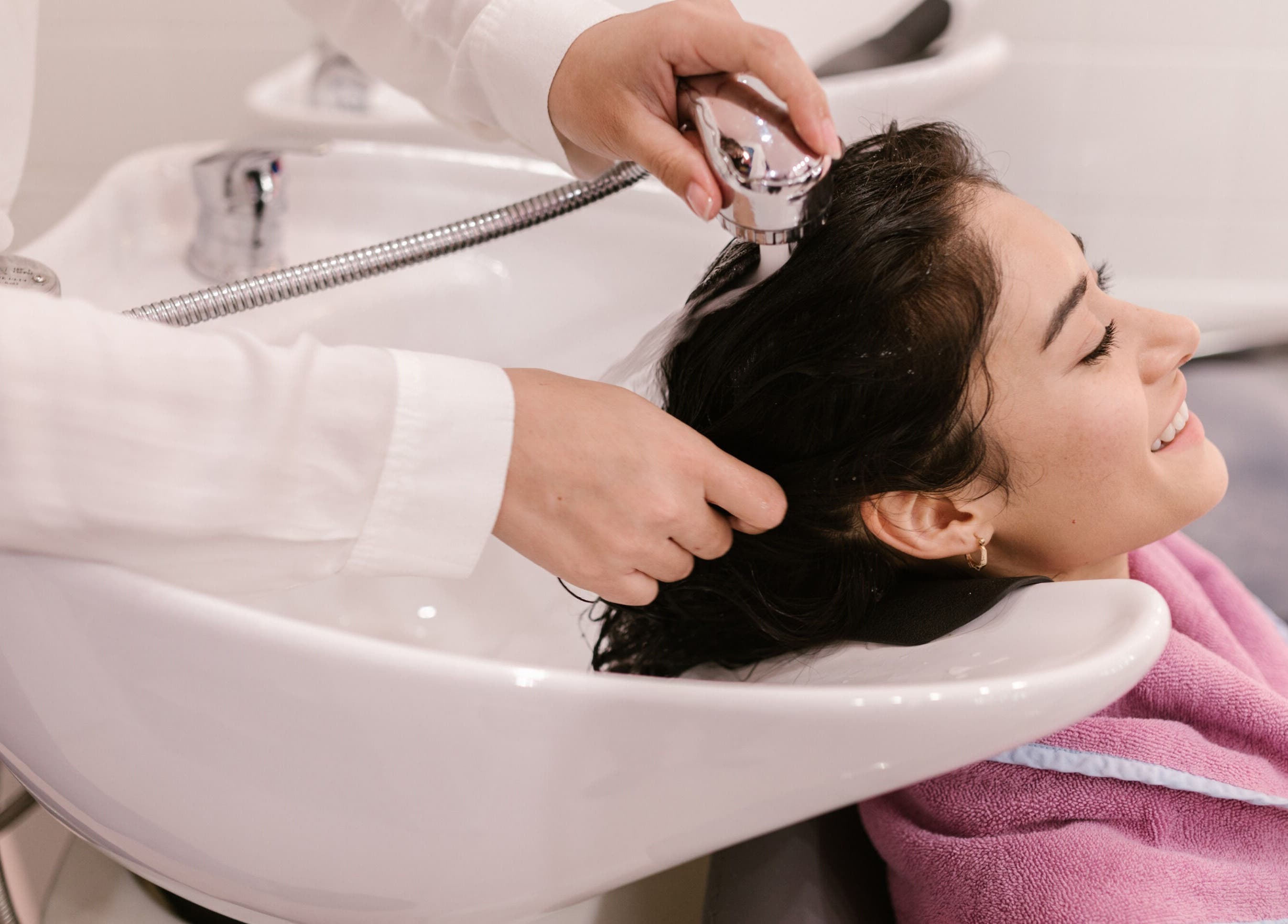 Client souriante recevant un soin cheveux chez romaindesigncode, Montpellier, Occitanie, FR.