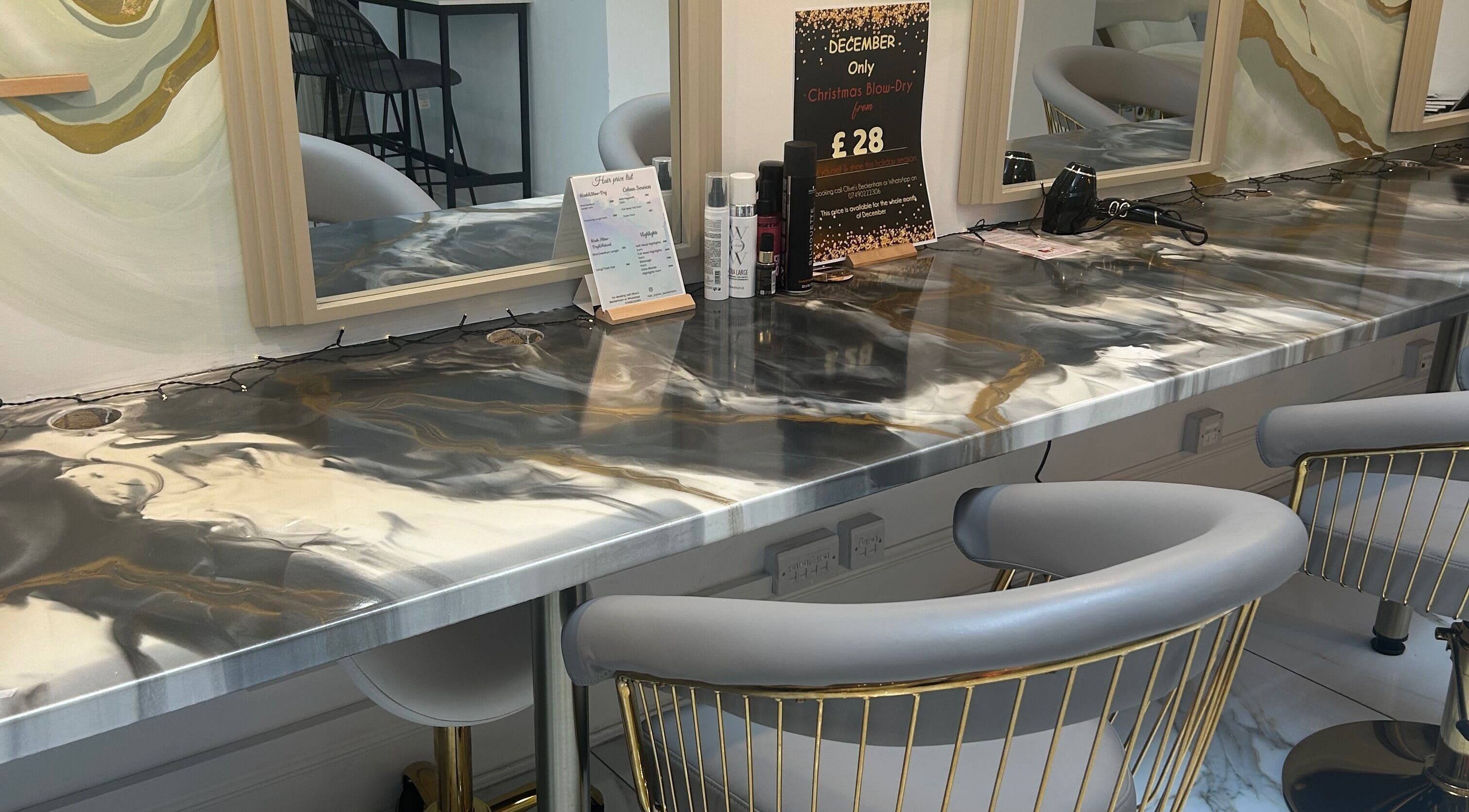 Chic hair styling station at Lola’s Hair, Beckenham, England, GB with marble counter and plush seating.