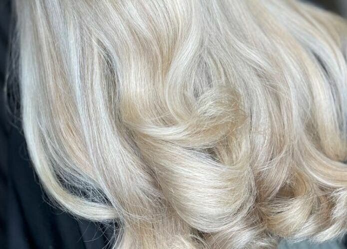 Elegant blonde waves styled at Mi Amour salon in Audenshaw, England, GB. Perfect shine and volume on display.