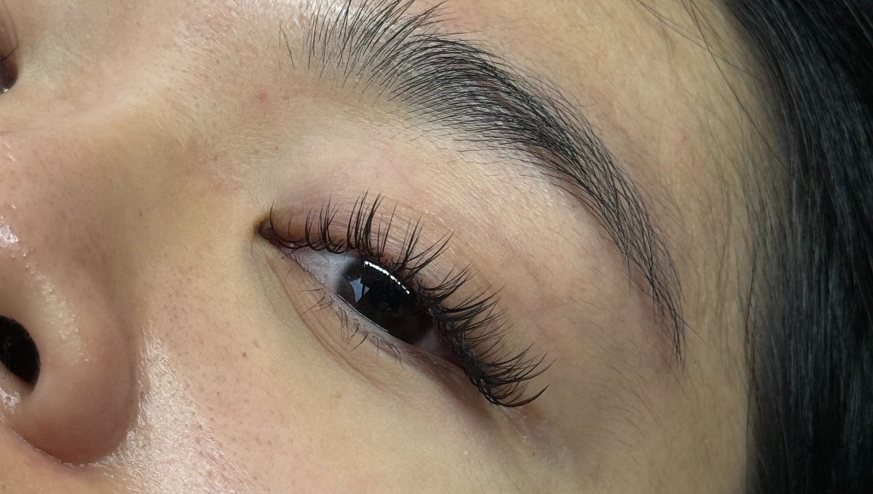 Close-up of elegant eyelash extensions at PHXLASH, London, England, GB, showcasing meticulous lash artistry.