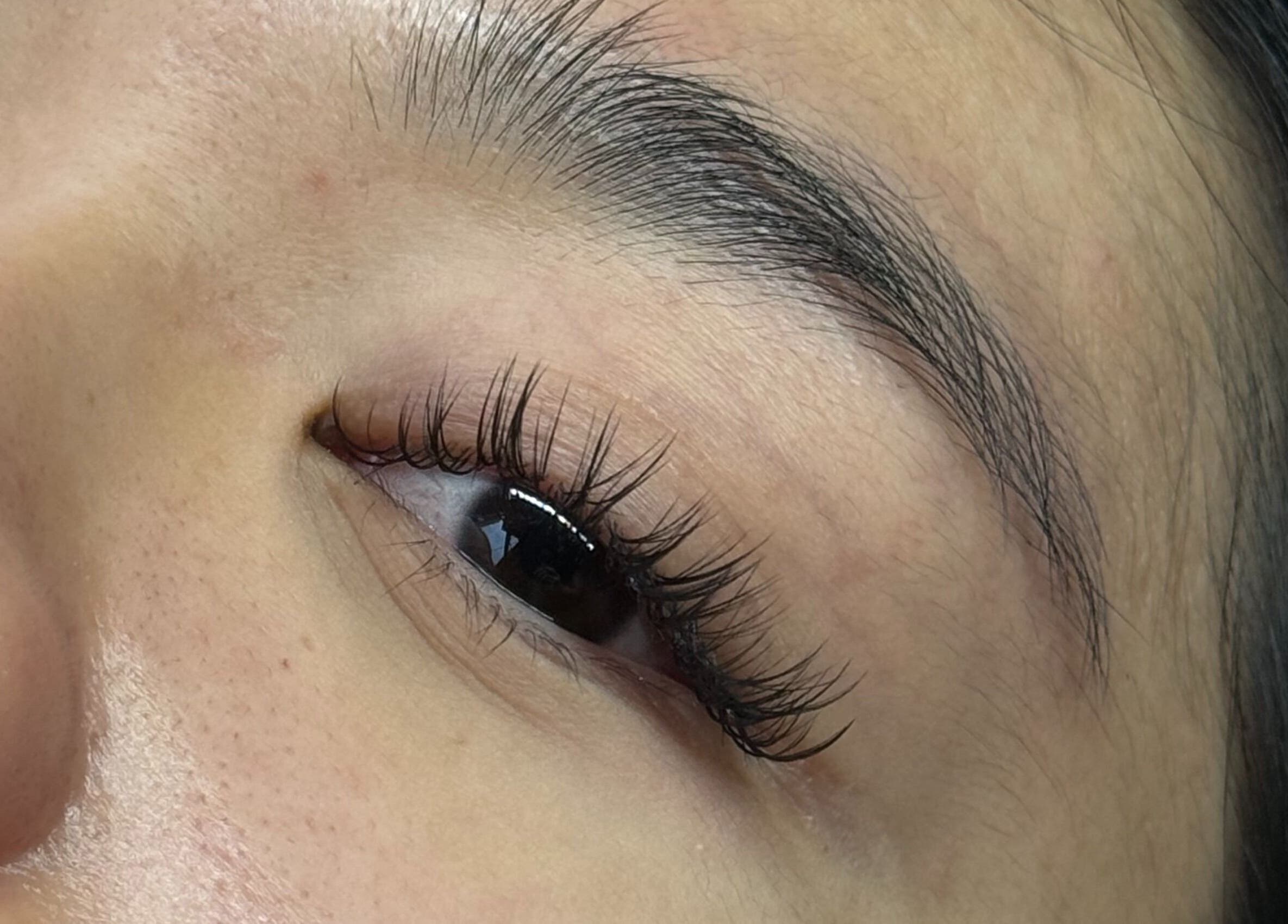 Close-up of elegant eyelash extensions at PHXLASH, London, England, GB, showcasing meticulous lash artistry.