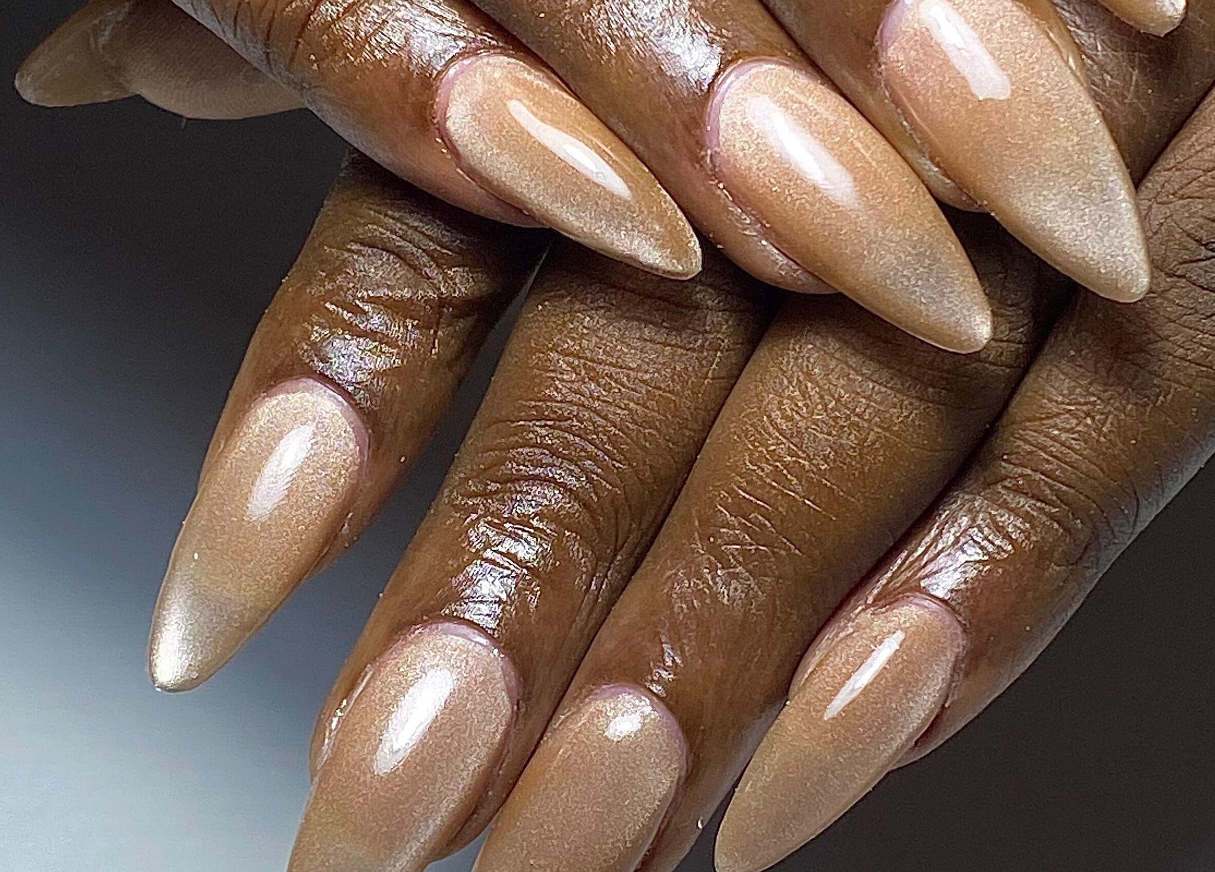 Glossy nail art in Paramaribo, Paramaribo, SR featuring shiny nude stiletto nails.