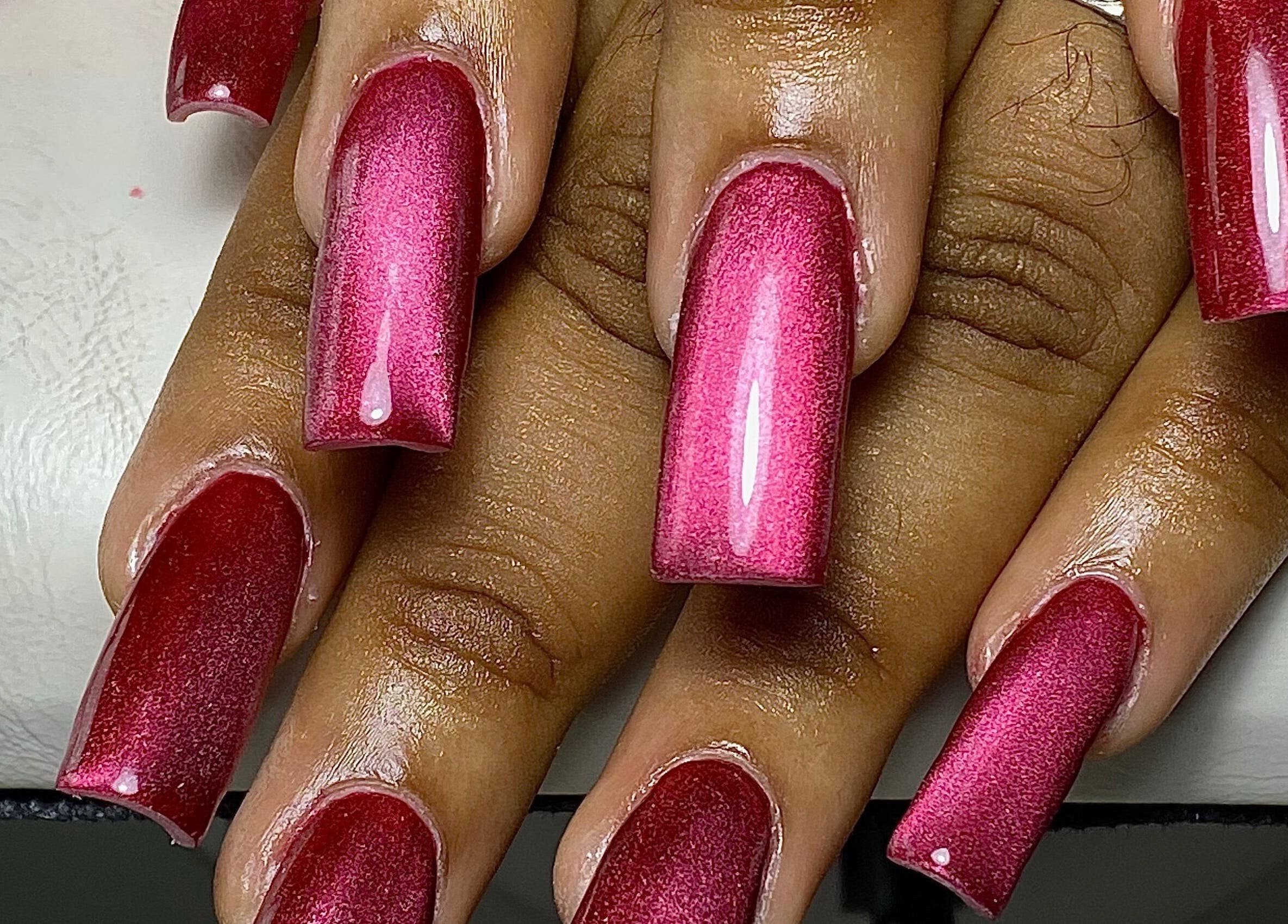 Elegant glossy red nails at Glossy salon, Paramaribo, SR. A stunning manicure showcasing vibrant style and beauty.